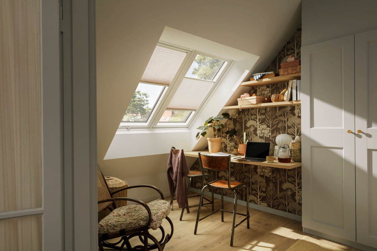 Home office with VELUX skylights and garden view through open doors.