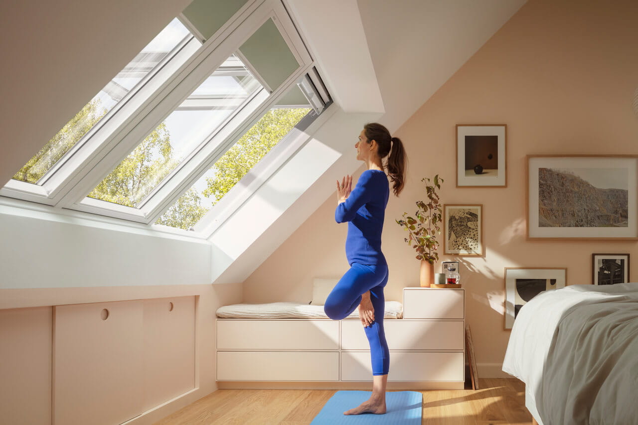 Quarto luminoso com janela de telhado VELUX e espaço para prática de ioga