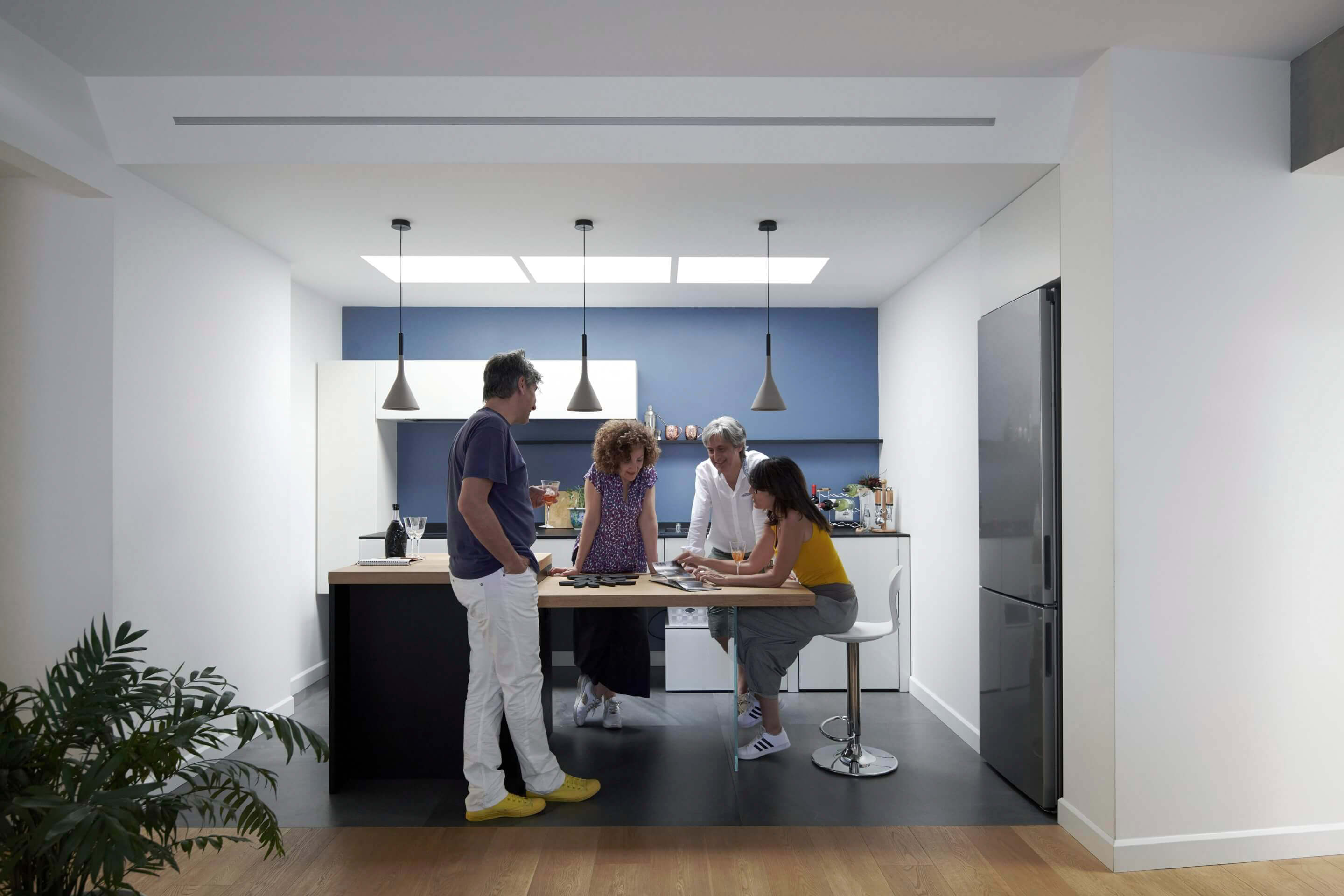 Renforcement des liens familiaux dans une cuisine moderne avec une fenêtre de toit VELUX et une décoration élégante.