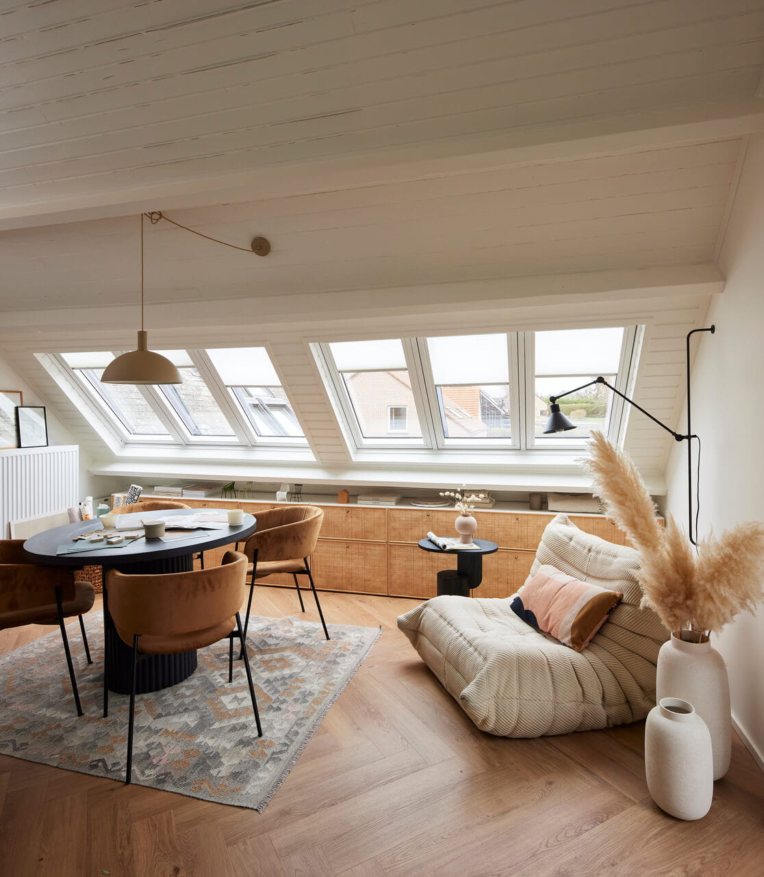 Espace repas moderne dans le grenier avec des fenêtres de toit VELUX et un mobilier chic.
