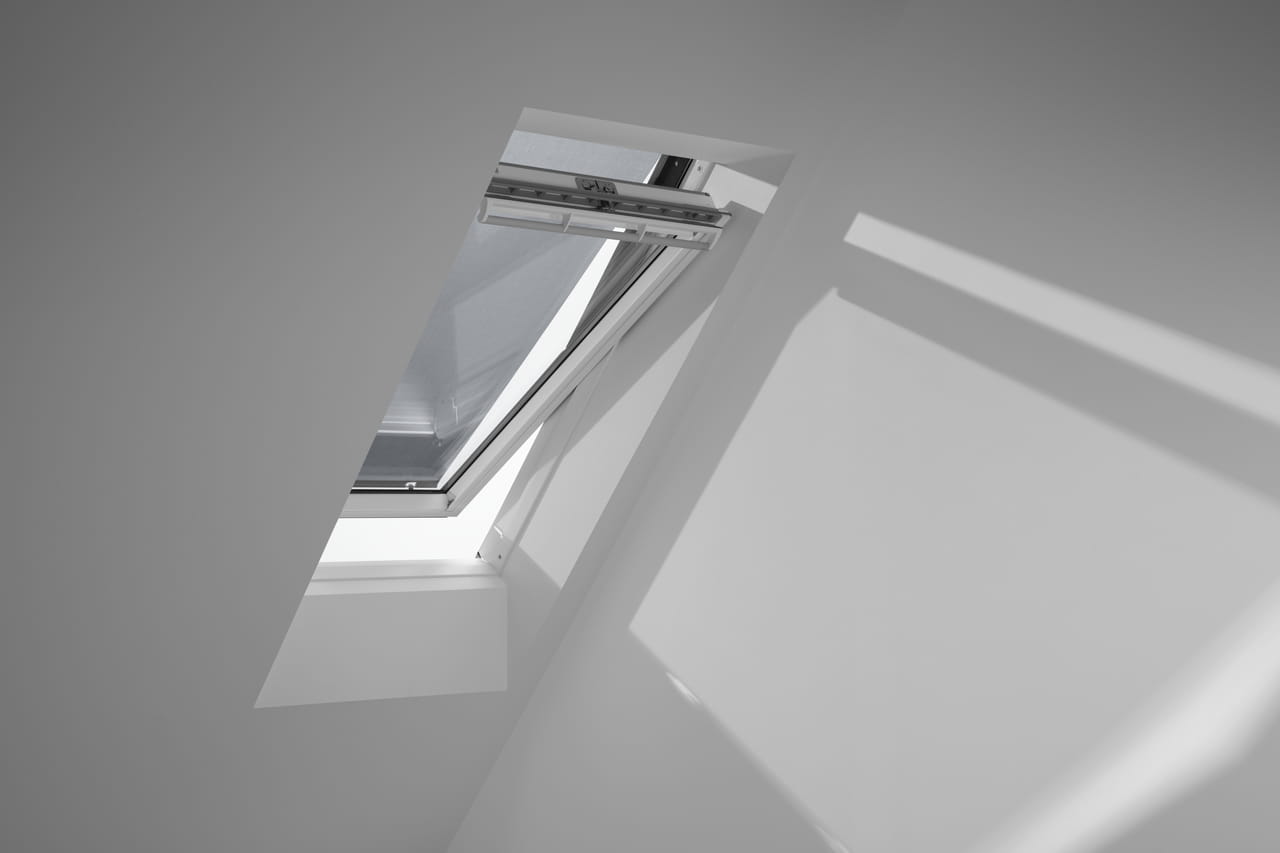Ein teilweise geöffnetes VELUX Dachflächenfenster in einem hellen, minimalistischen Raum.