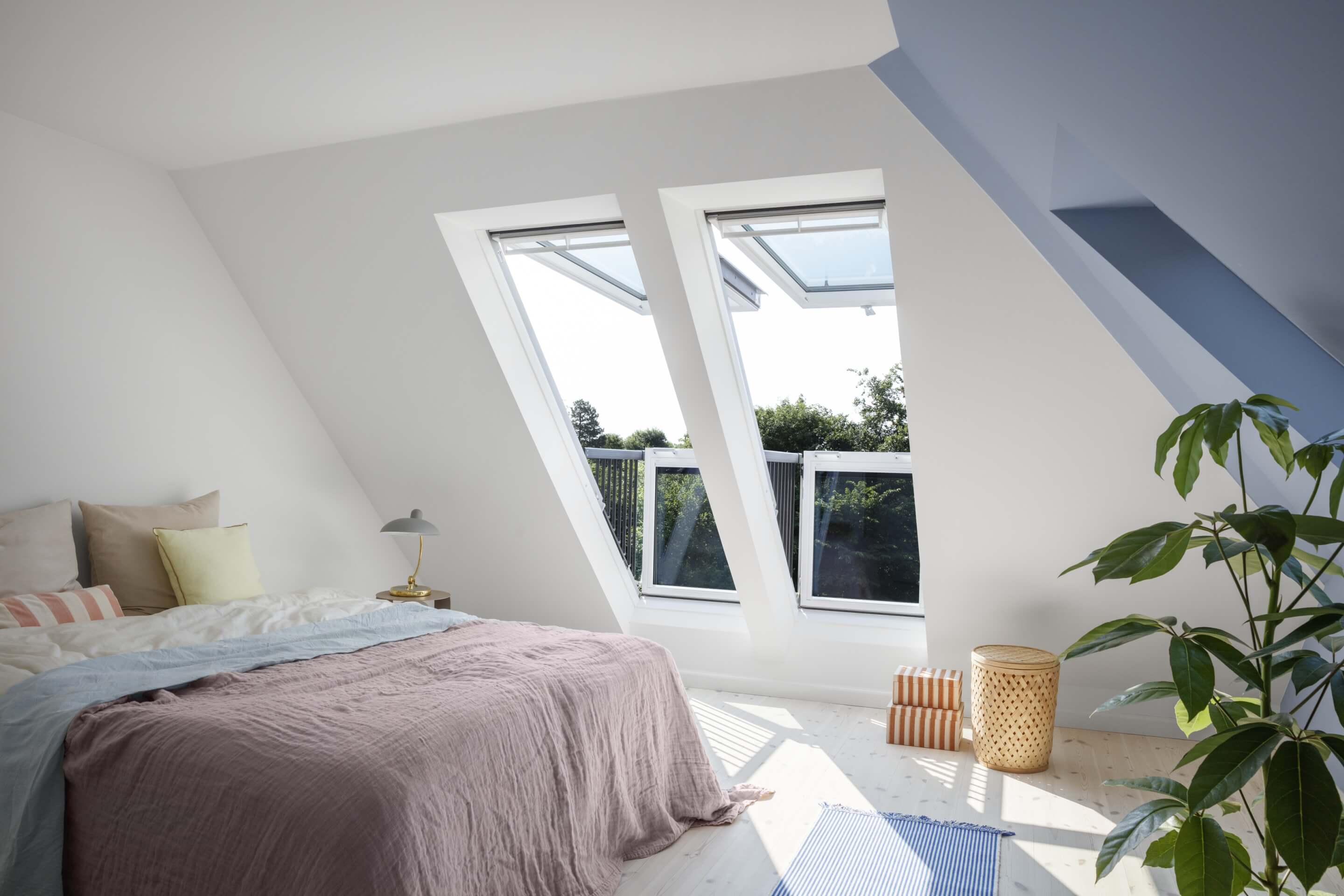Schlafzimmer im Dachboden mit VELUX Dachflächenfenstern und einem Hauch von Grün.