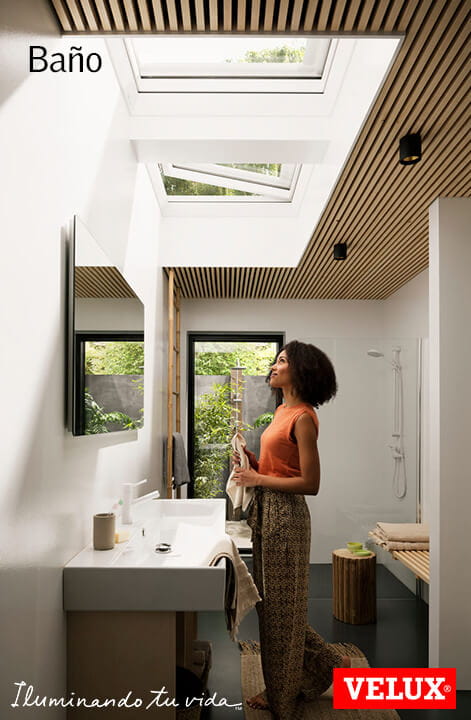 Modernes Badezimmer mit natürlichem Licht von VELUX Dachflächenfenstern und Aussicht auf Grünanlagen.