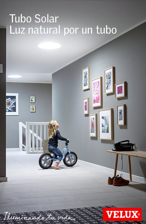 Kind fährt mit dem Fahrrad in einem Korridor, der durch ein VELUX Dachflächenfenster beleuchtet wird, mit Wandkunst.