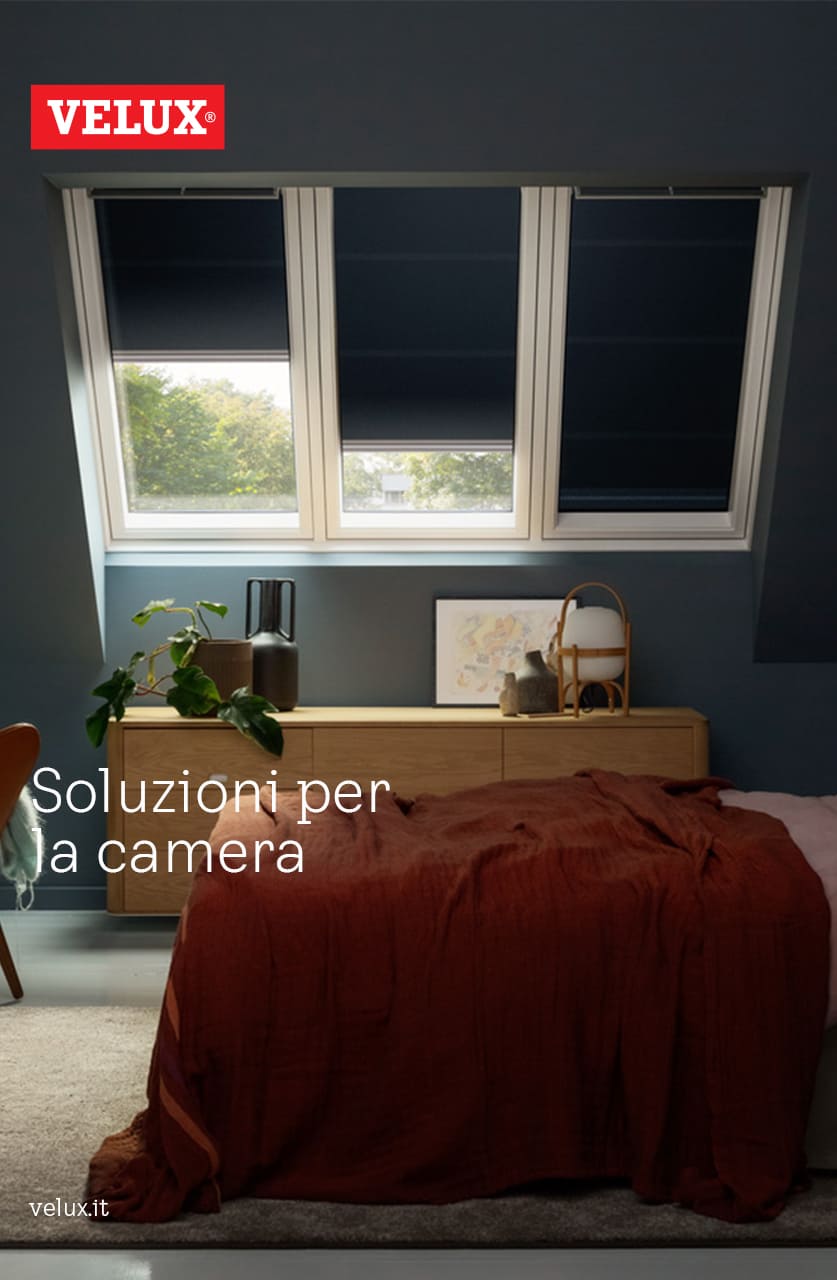 Schlafzimmer mit VELUX-Fenstern, die Tageslicht hereinlassen, rostfarbene Bettdecke auf dem Bett, moderne Einrichtung.