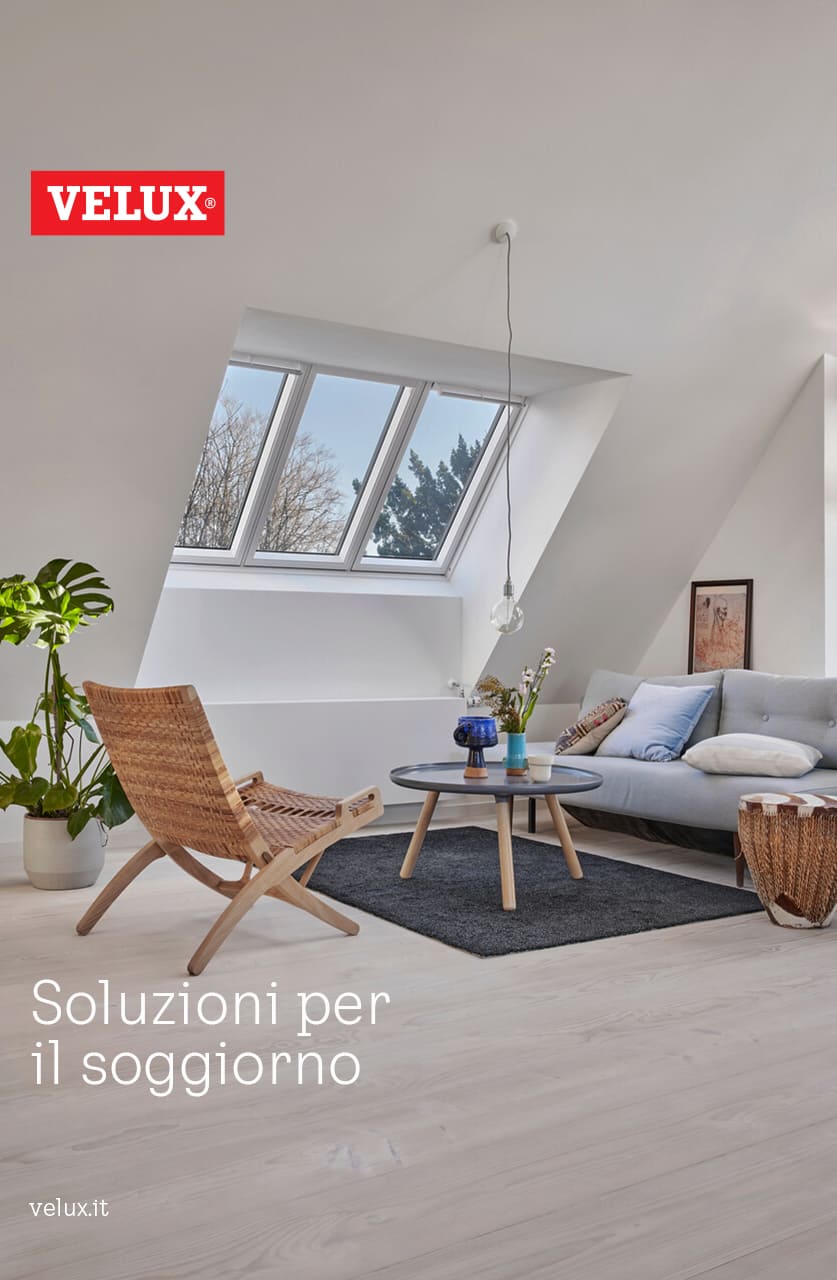 Wohnzimmer im Dachboden mit natürlichem Licht von VELUX Dachflächenfenstern, eingerichtet mit Sofa und hölzernem Stuhl.