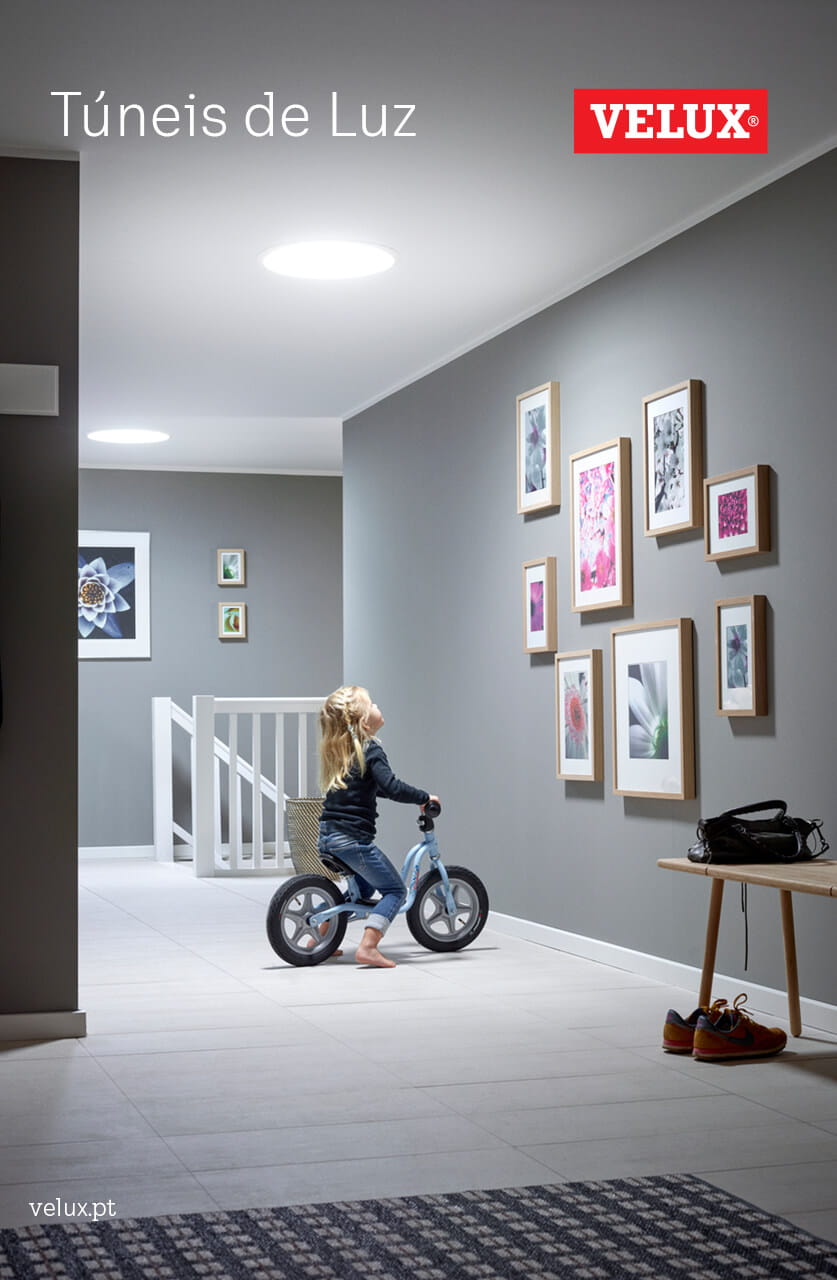 Kind fährt mit dem Fahrrad im Korridor mit VELUX Dachflächenfenster und Wandkunst.