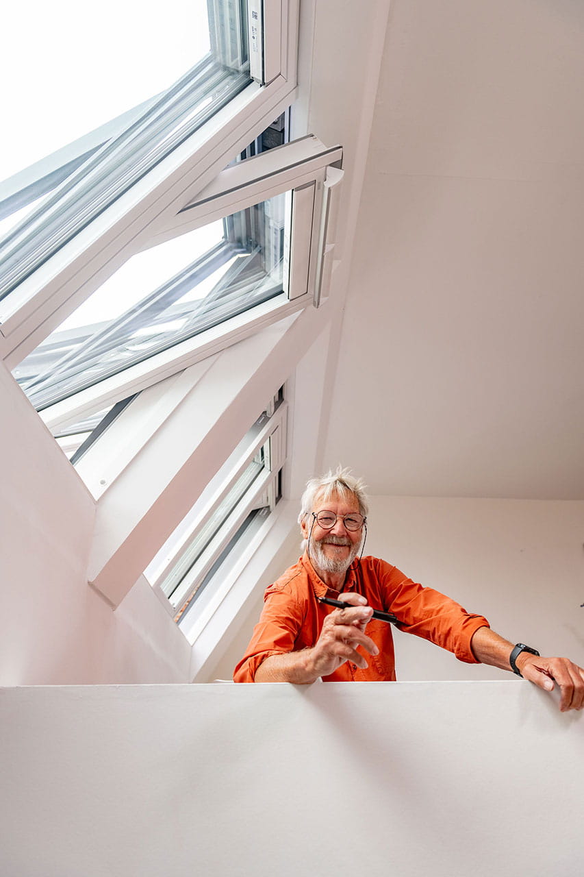 Happy man smiling under his 3in1 VELUX roof windows