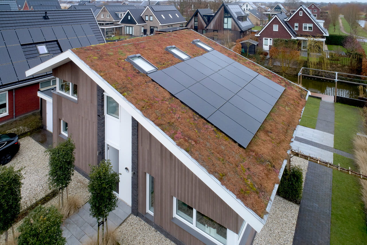 A view from above to a house with roof windows and solar panels.