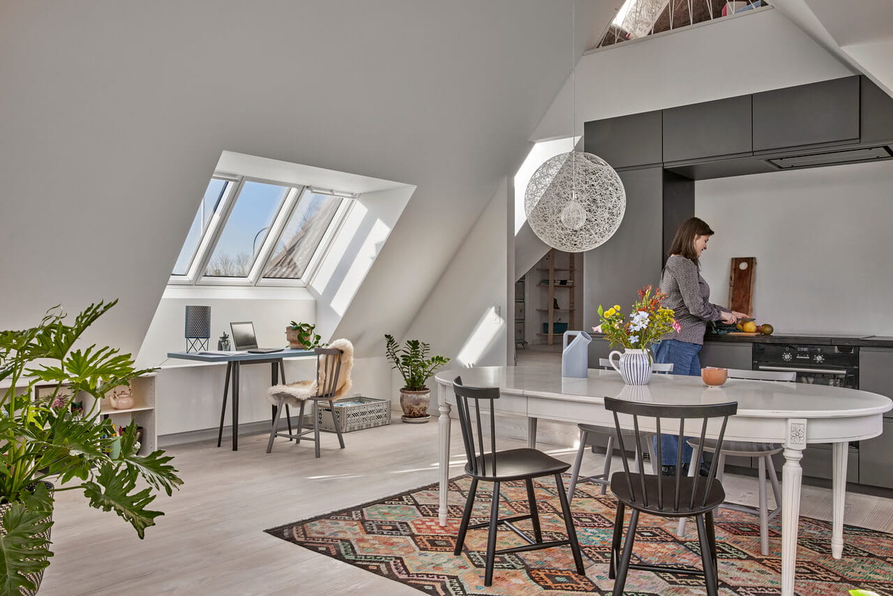 Moderne hjemmekontor på loftet med VELUX-vindu og tilstøtende kjøkkenområde.