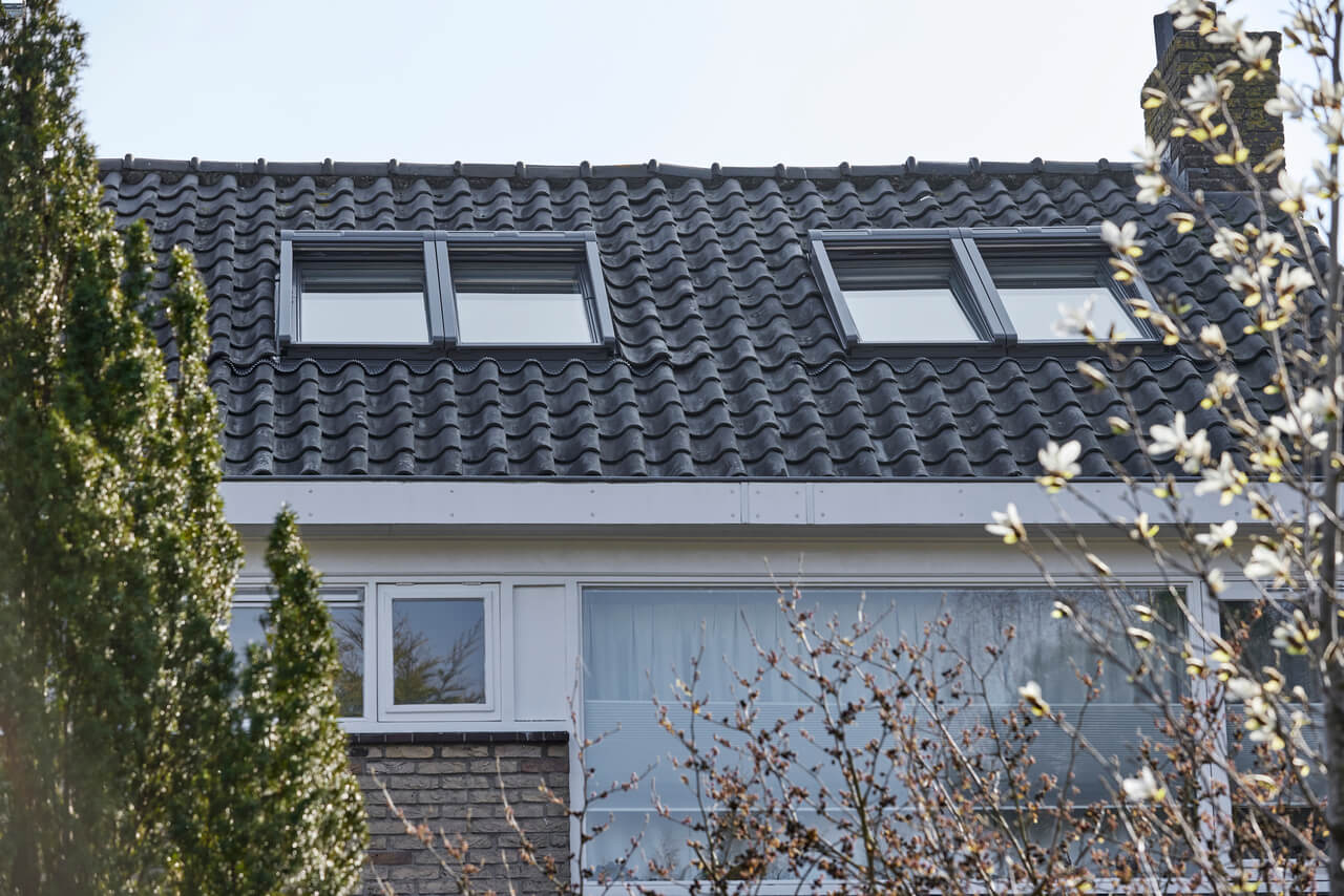 Modern residentieel gebouw met VELUX dakvensters tegen donkere dakpannen
