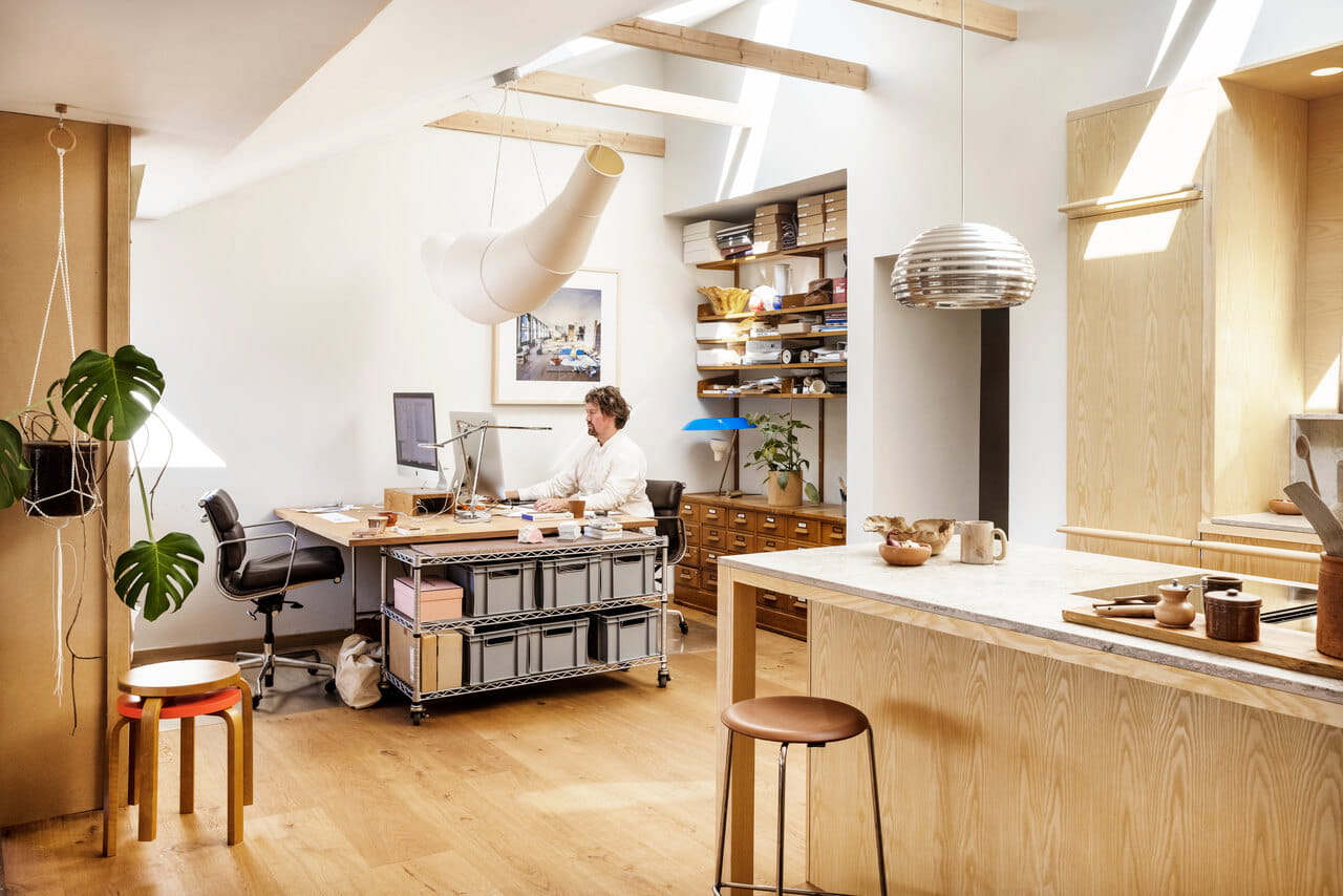 Oficina moderna en casa con ventanas de tejado VELUX y área de cocina adyacente.