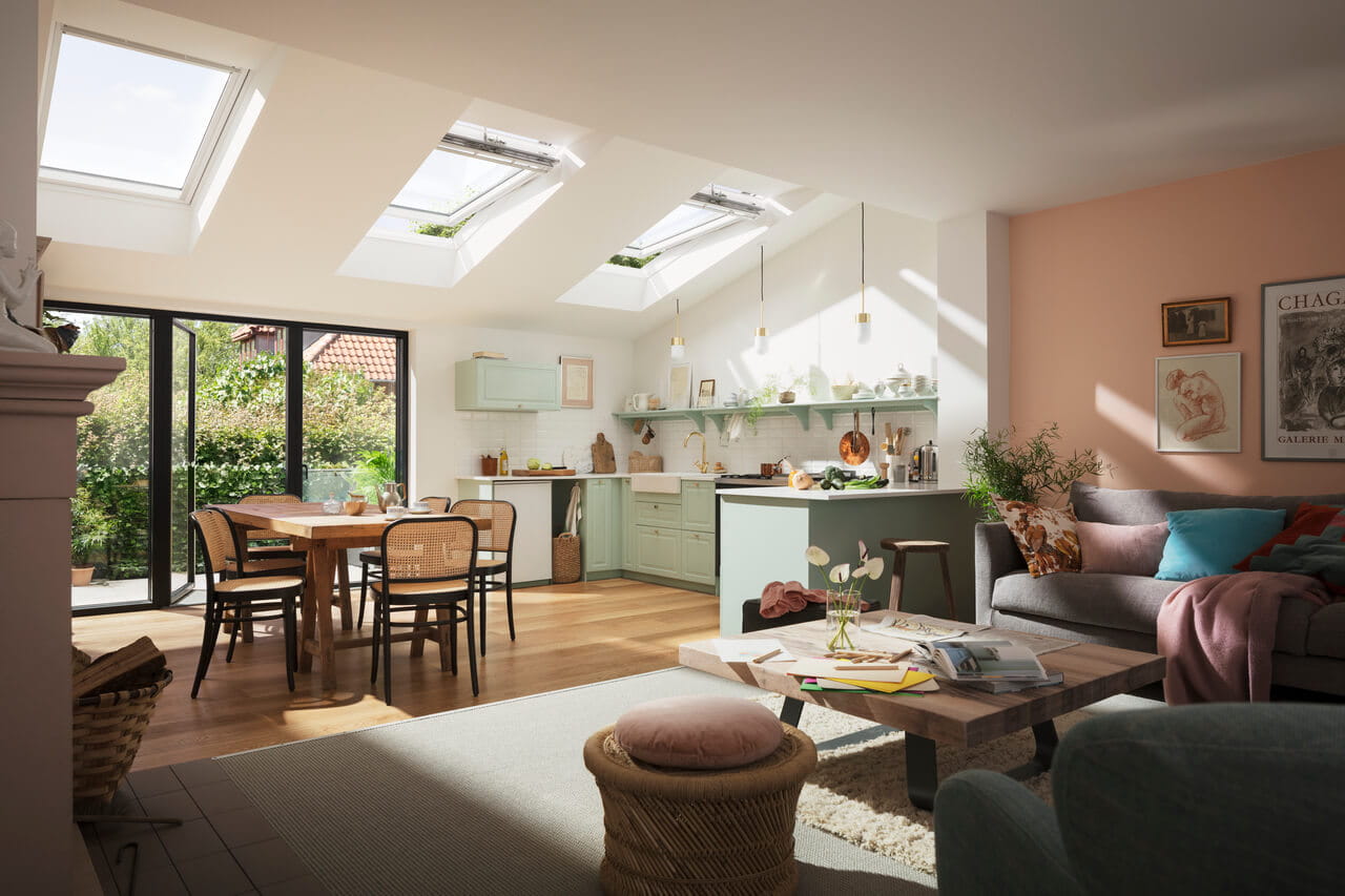 Cocina y comedor de concepto abierto con luz natural de las ventanas de tejado VELUX.