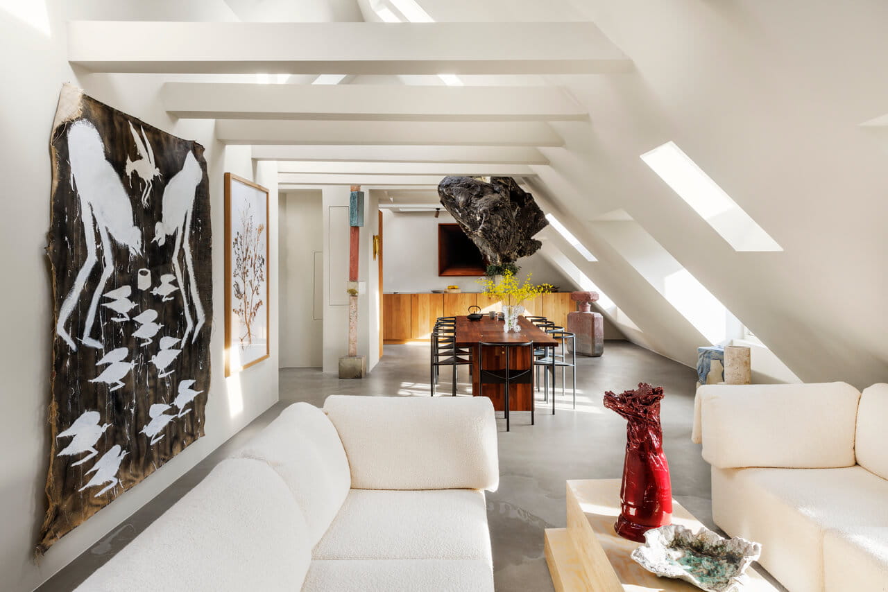 Sala de estar moderna tipo loft con ventanas de tejado VELUX y decoración artística ecléctica.