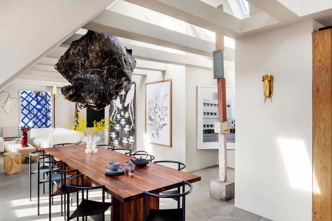 Moderne eetkamer met natuurlijk licht van VELUX dakvensters, art-decostijl en houten tafel.