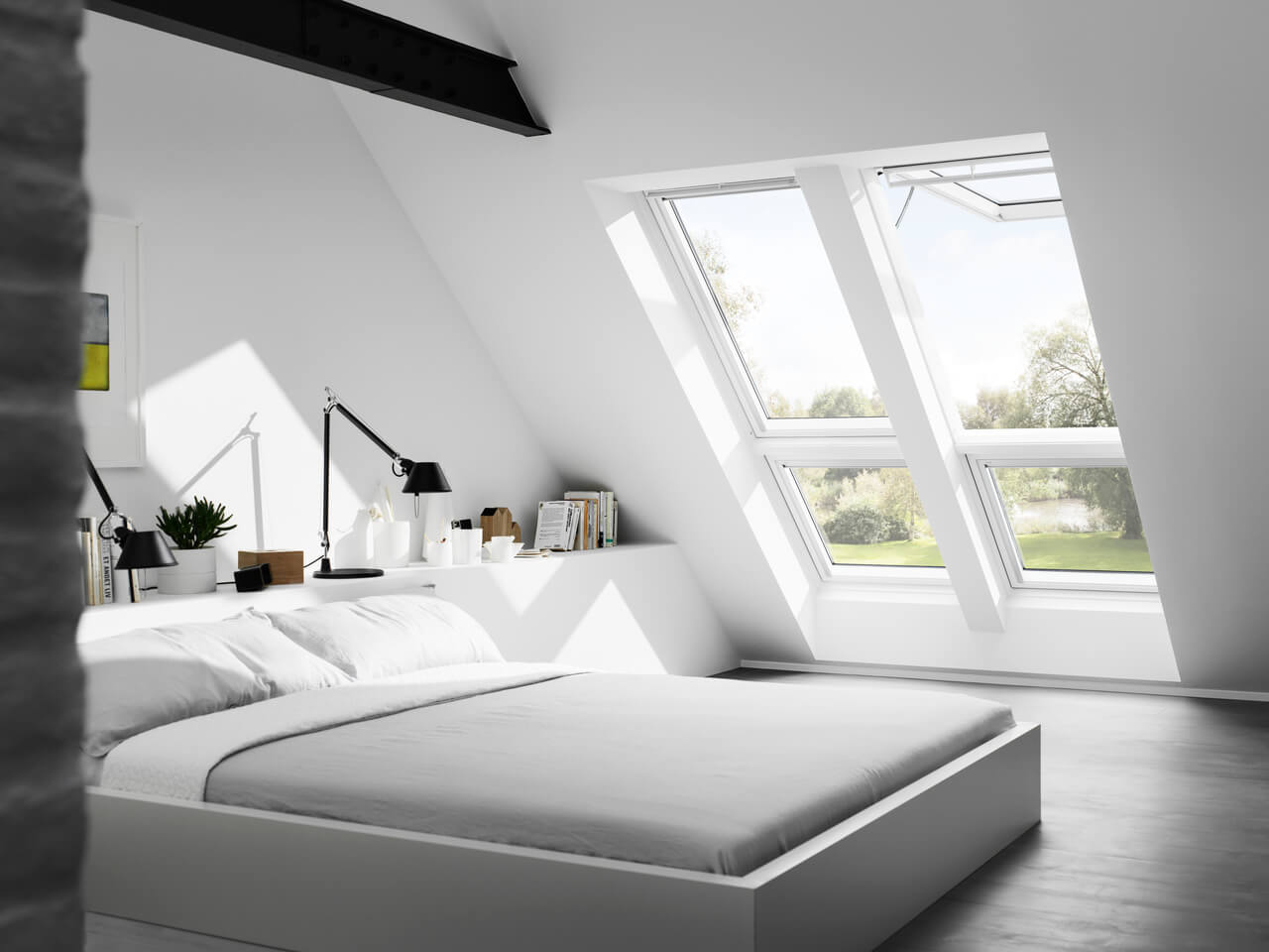 Quarto moderno no sótão com janelas de telhado VELUX e decoração minimalista.