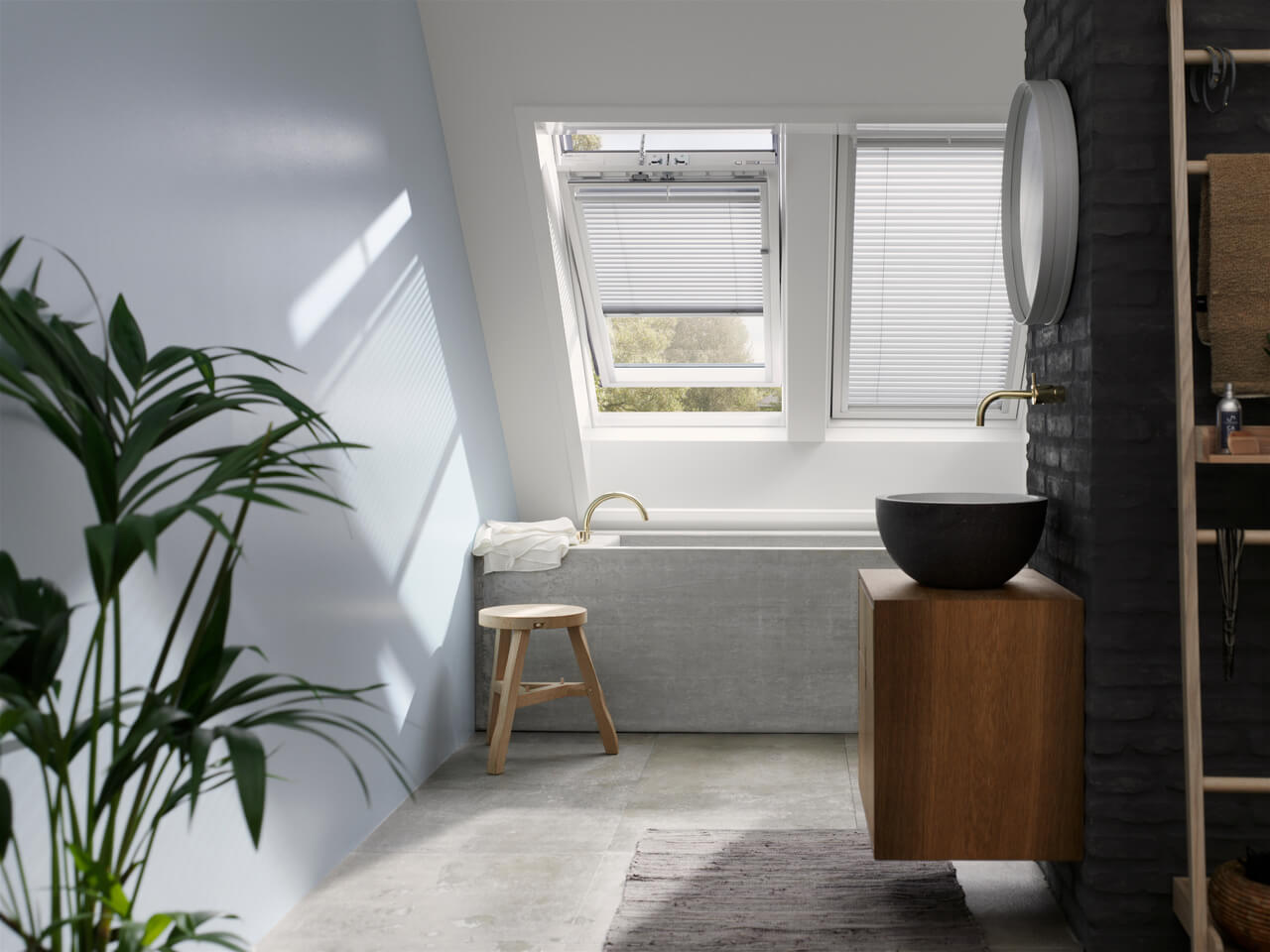 Modernt badrum med VELUX takfönster, rund spegel och träfåfänglighet.