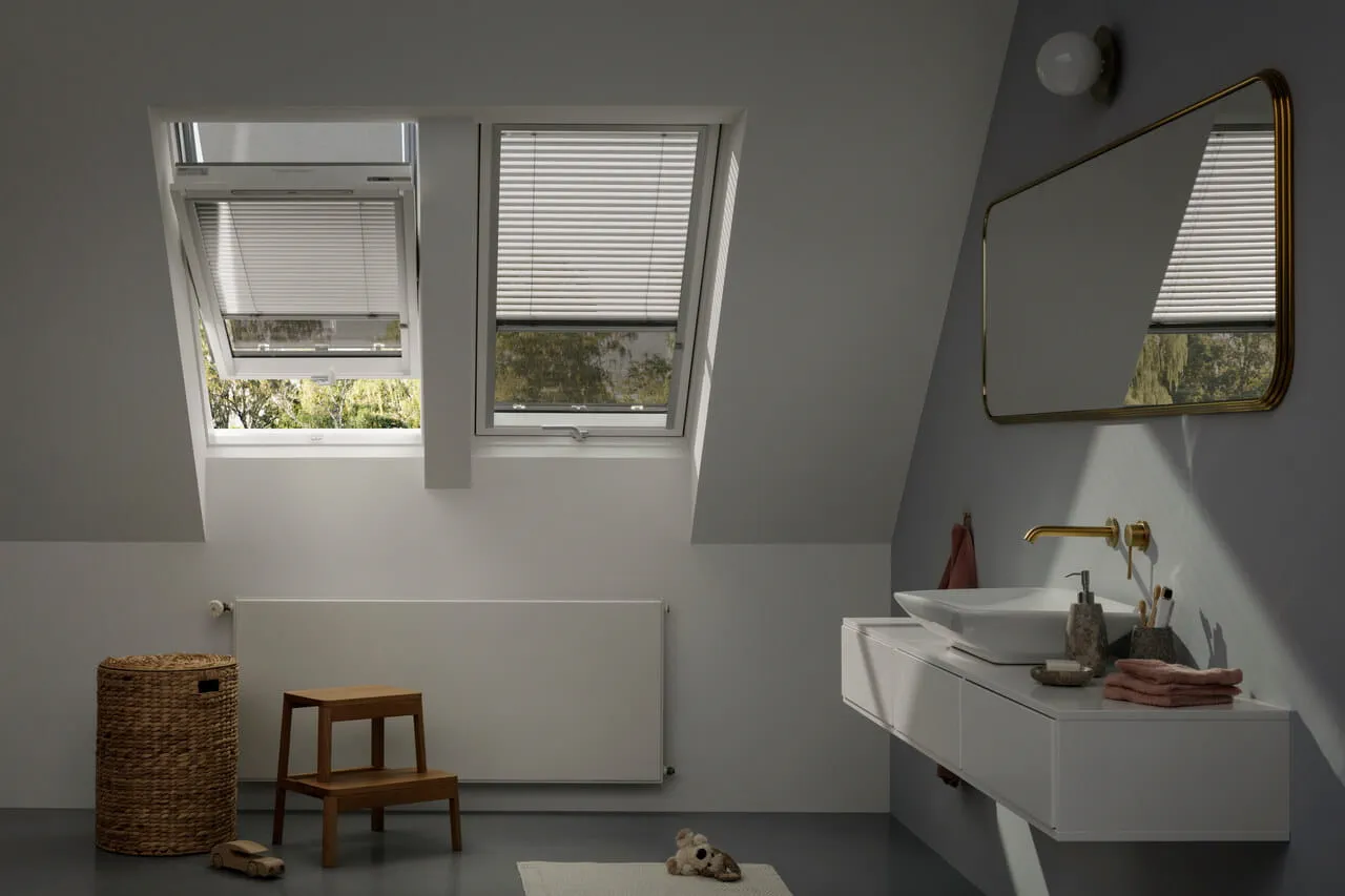 Salle de bain contemporaine avec fenêtre de toit VELUX et décoration minimaliste.