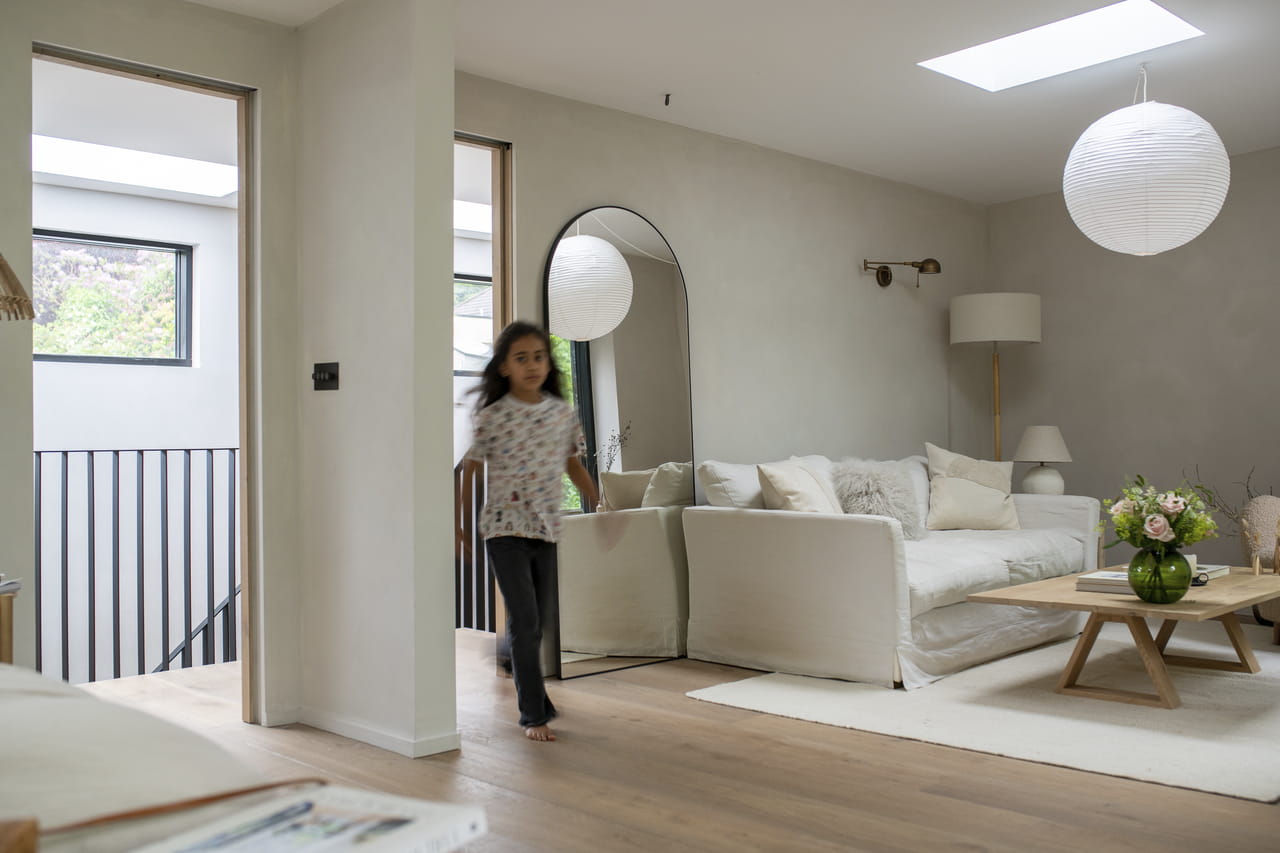 Girl running in bright livingroom with VELUX flat roof window