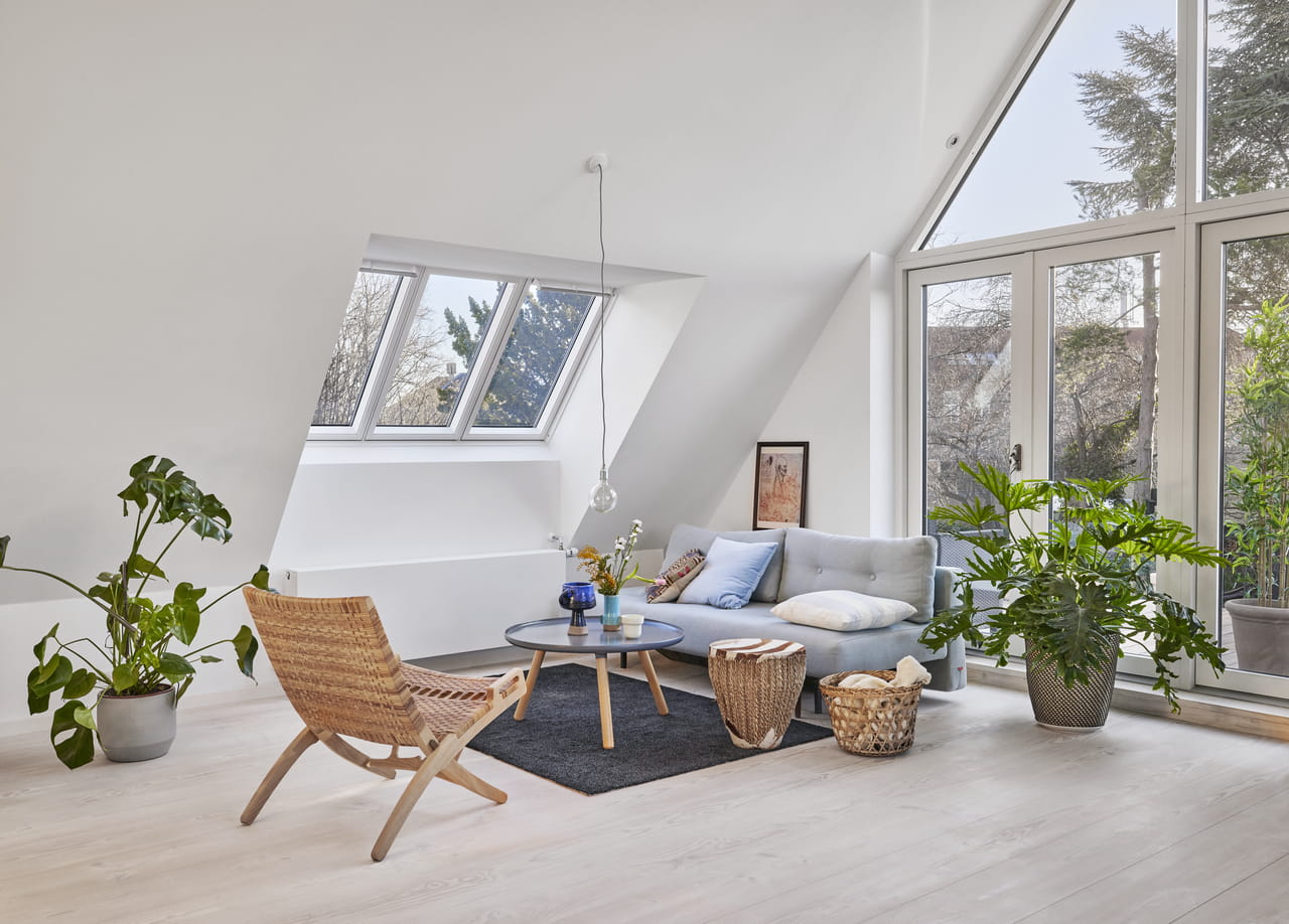 Cozy attic living room with VELUX roof windows and natural light.