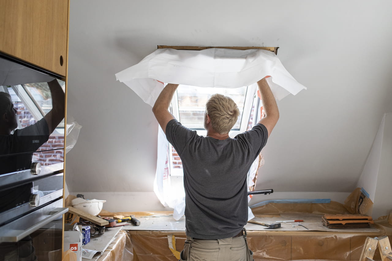 Craftsman fitting a VELUX skylight in a contemporary kitchen environment.