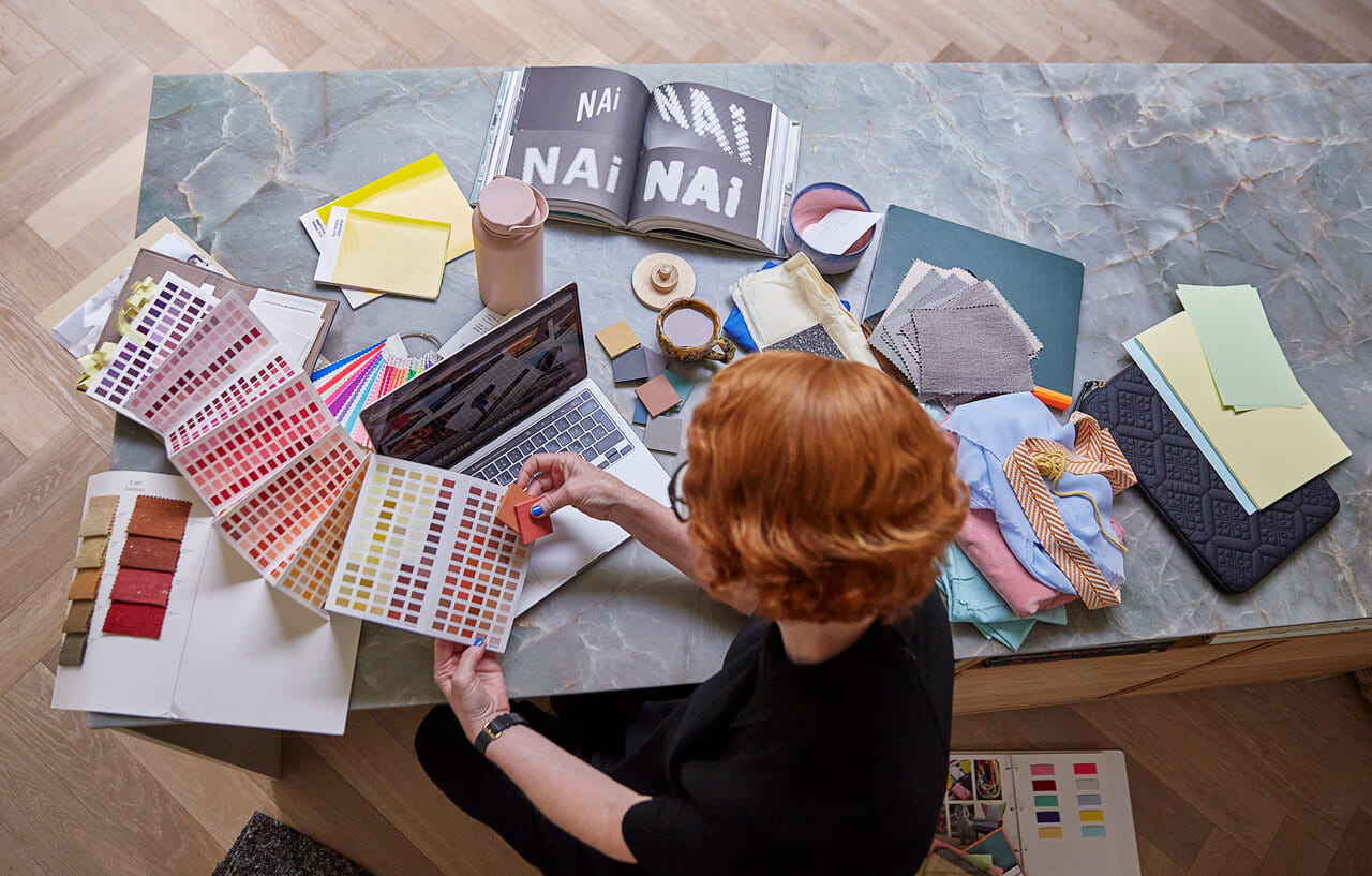 Designer d'intérieur choisissant parmi des échantillons de couleurs et des matériaux pour un projet.