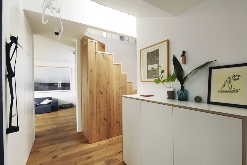 Contemporary home interior with wooden staircase and VELUX skylight lighting.