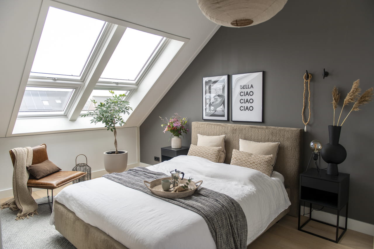 Camera da letto moderna in mansarda con finestre per tetti VELUX e arredamento contemporaneo.