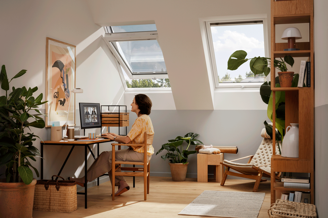 Home office with VELUX skylights, plants, and a cosy reading nook.