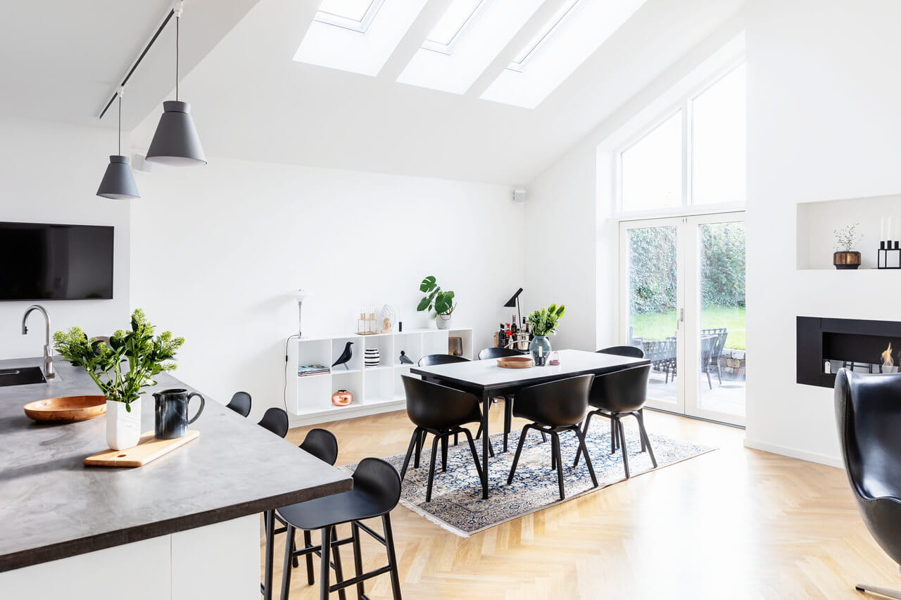 Modern kitchen interior with VELUX windows, marble island, and garden view.