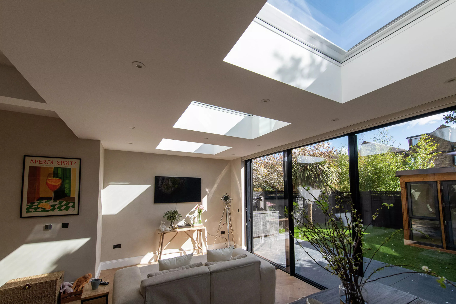 Soggiorno moderno con finestre per tetti VELUX e vista sul giardino.