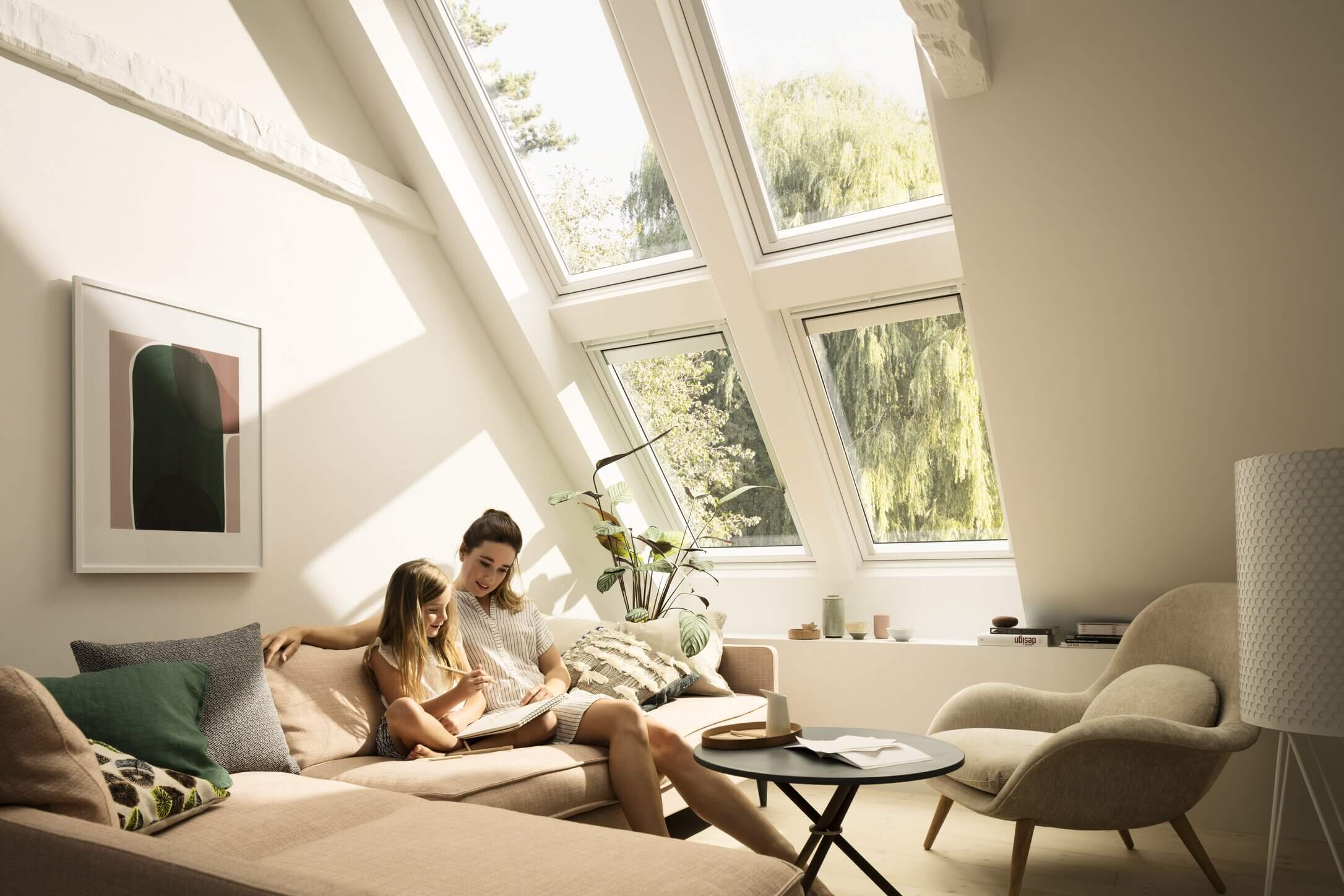 Gemütliches Wohnzimmer mit natürlichem Licht von VELUX Dachflächenfenstern und moderner Einrichtung.