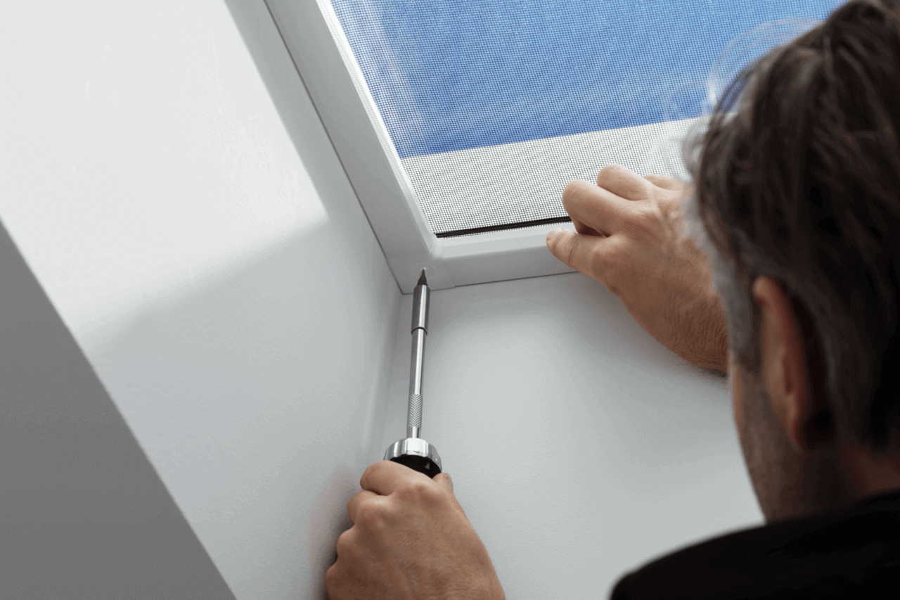 Nahaufnahme von Händen, die ein VELUX Dachflächenfenster zur Verbesserung der Beleuchtung einbauen.