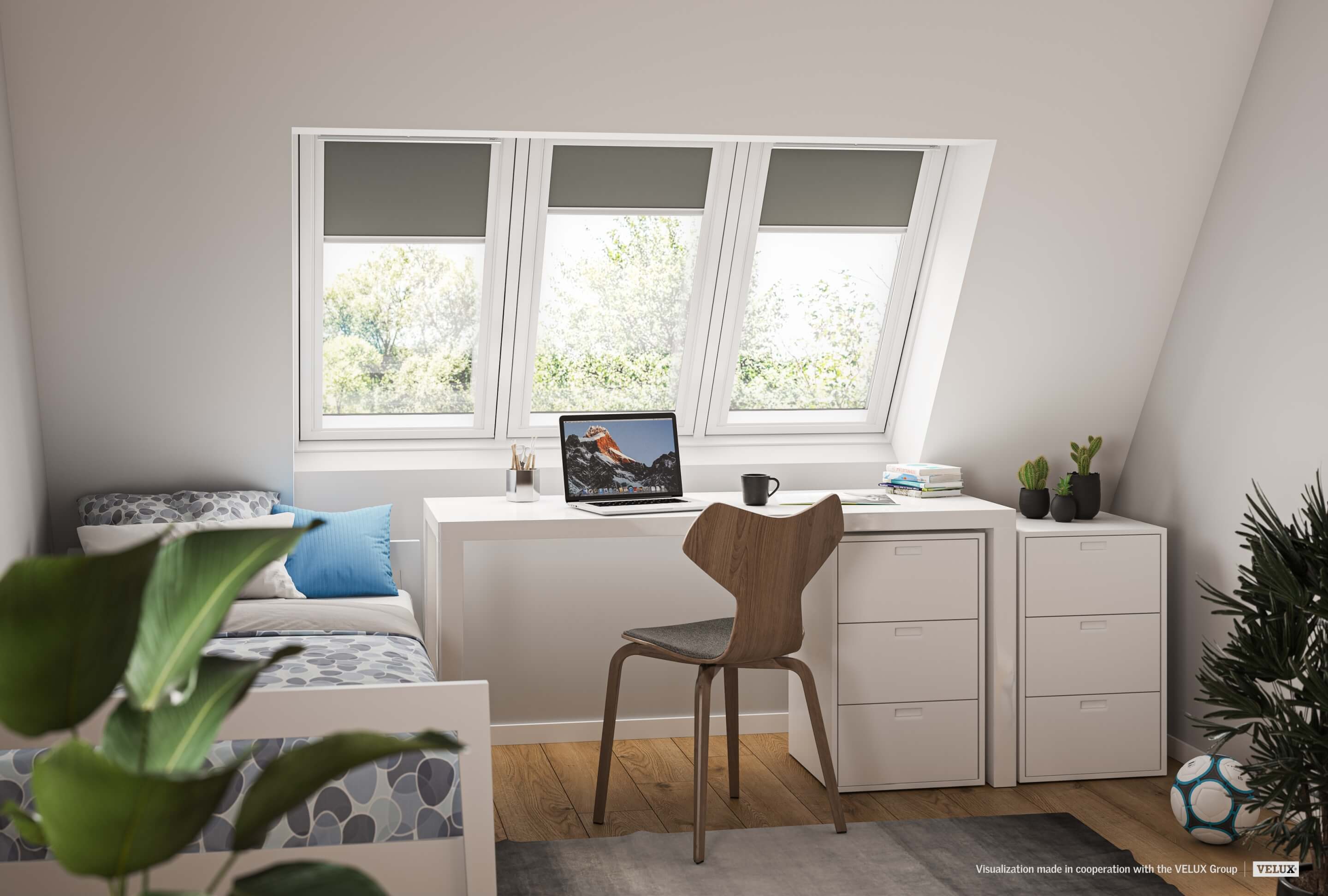 Home-Office-Ecke mit Schreibtisch, Stuhl und VELUX Dachflächenfenster mit Blick auf grüne Bäume.