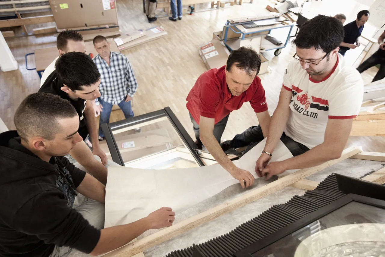 A group of people in a workshop learning how to install a VELUX window
