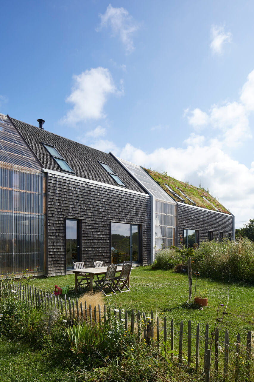 Nachhaltiges Wohnhaus mit Gründach und VELUX-Fenstern, umgeben von einem Garten.
