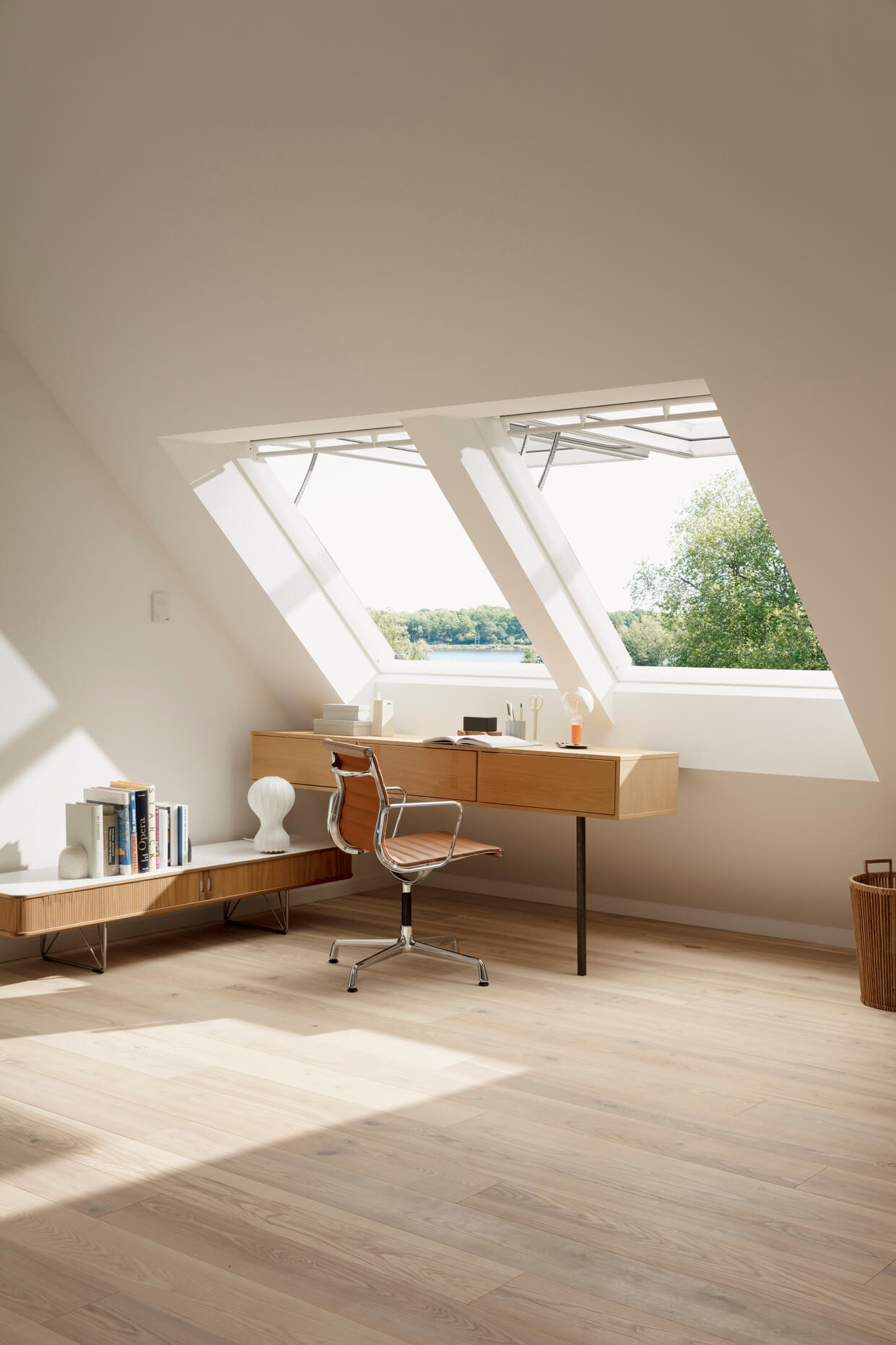 Modernes Dachboden-Homeoffice mit VELUX Dachflächenfenster und hölzernen Möbeln.
