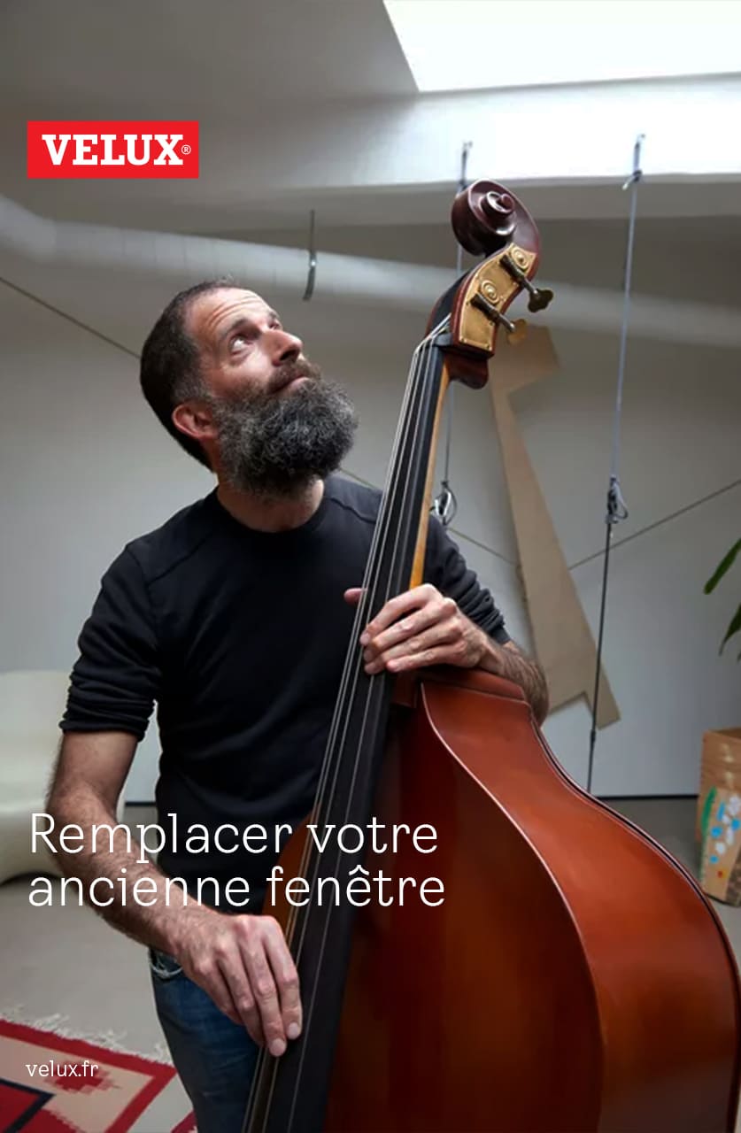 Musiker in einem gemütlichen Raum mit einem VELUX Dachflächenfenster, der einen Kontrabass spielt.