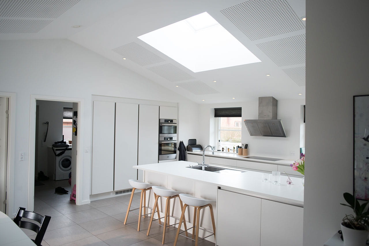 Helle moderne Küche mit weißer Insel, Geräten und VELUX Dachflächenfenster.