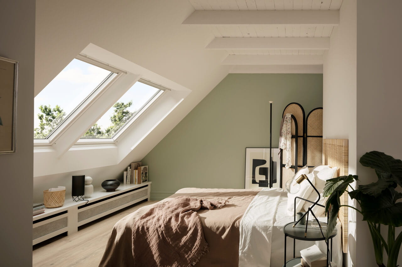 Modernes Schlafzimmer mit natürlichem Licht von VELUX Dachflächenfenstern, das eine ruhige Atmosphäre schafft.