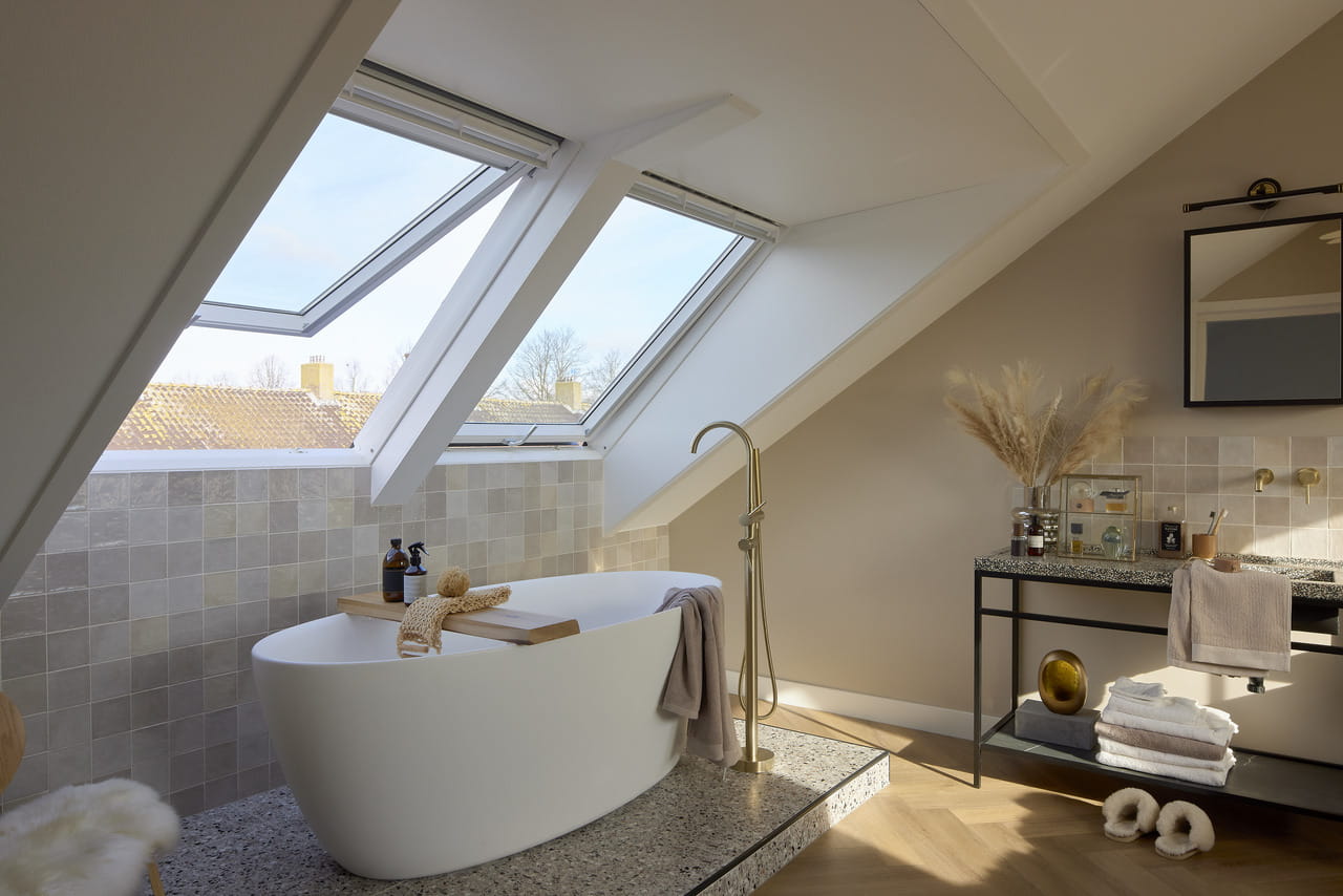 Modernes Badezimmer im Dachboden mit VELUX Dachflächenfenster und einer freistehenden Badewanne.