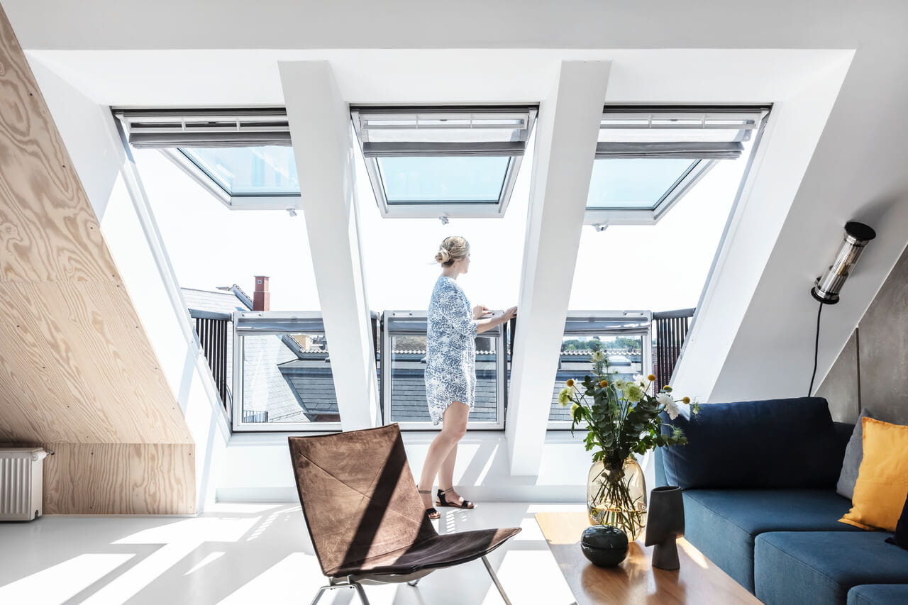 Woman standing by the roof balcony window from VELUX.