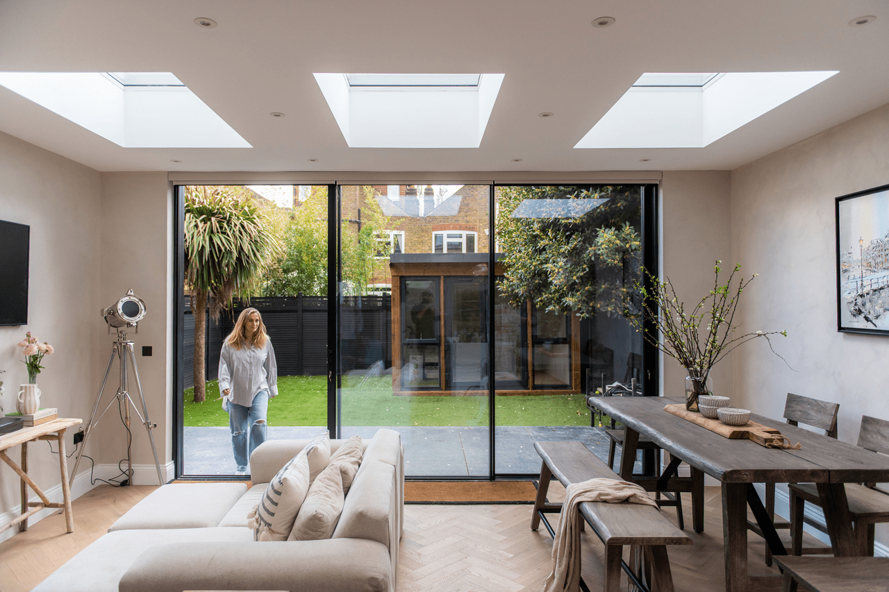 Modern living room with VELUX skylights and garden view through glass doors.