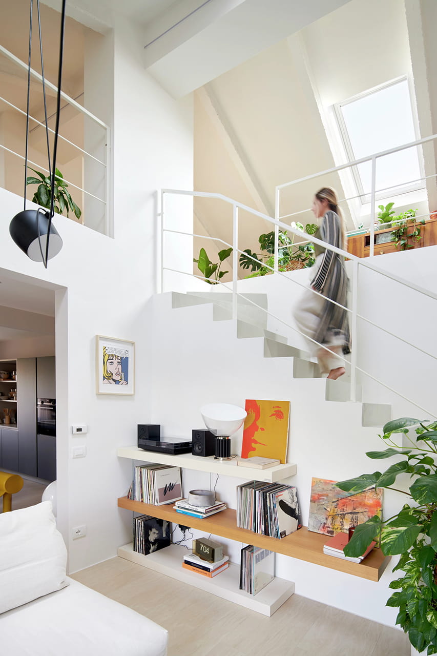 renovation home/office 1970s house Modena Sabrina walking up stair in double height room with roof windows