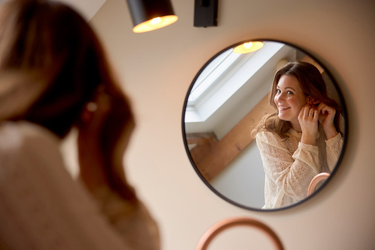 Woman looking at the mirror and smiling.