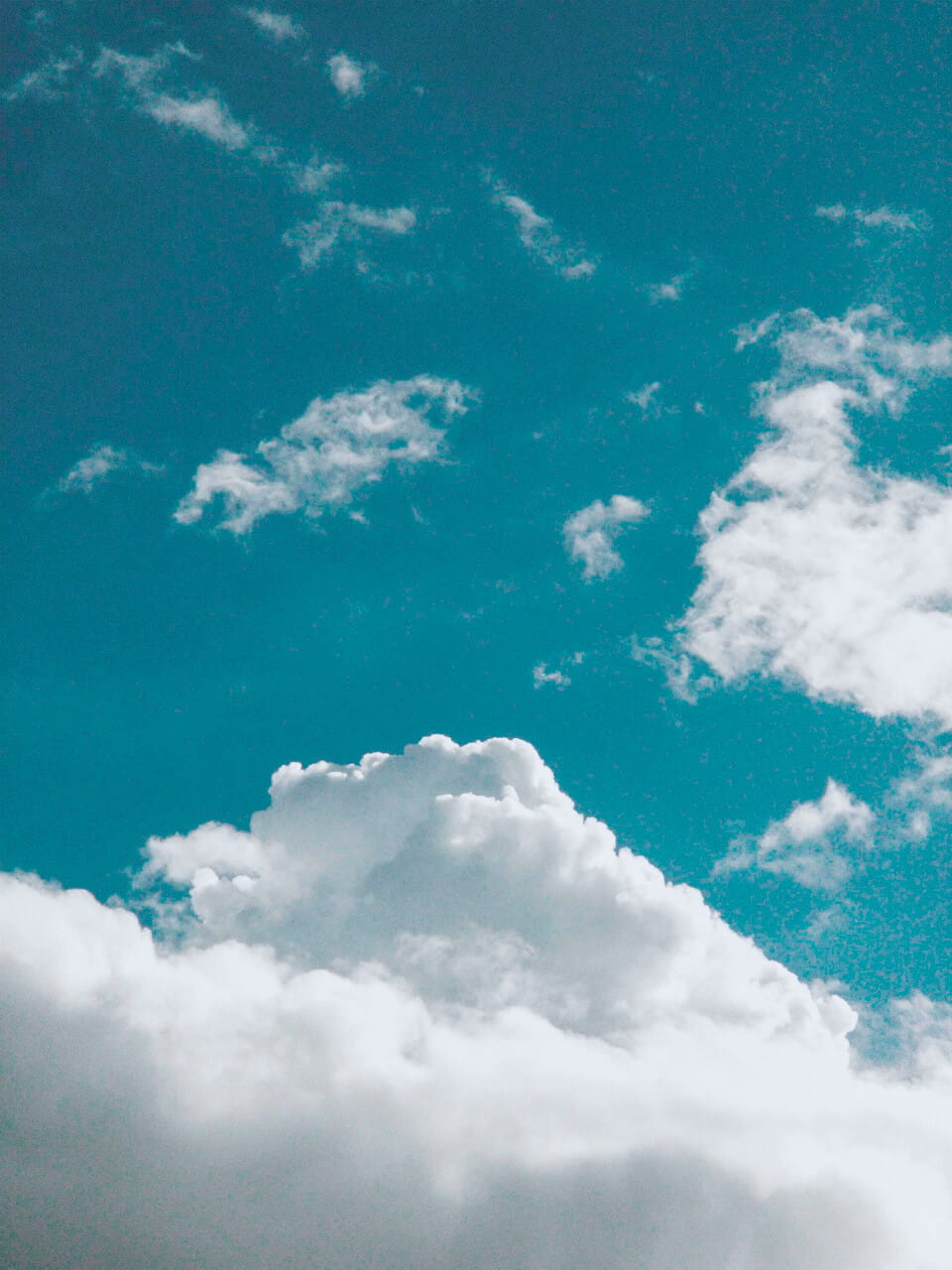 Lebhafter blauer Himmel mit sanften weißen Wolken, die Ruhe und natürliche Schönheit vermitteln.
